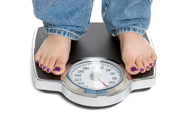 woman on scale after fat reuction treatments in Fremont